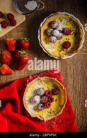 Crostata al limone con rosmarino e bacche, riempito con crema di frutti di bosco e rabboccato Foto Stock