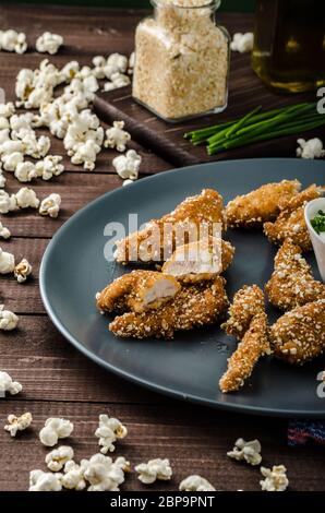 Le strisce di pollo nel pangrattato popcorn, con deliziosi aglio dip panini e toast Foto Stock