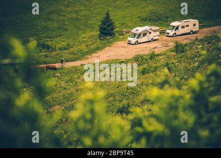 Due veicoli ricreativi bianchi di medie dimensioni parcheggiati sul lato di Rural Dirt Road. Foto Stock