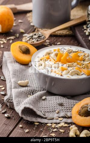 Albicocche domestico musli yogurt con il latte e croccante di dadi e sementi sane chia Foto Stock