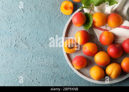 Composizione con vassoio di albicocche su fondo cementizio Foto Stock