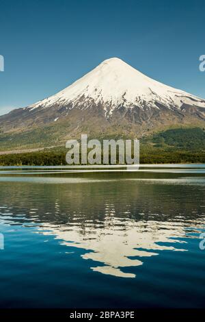 Il Volcan Osorno innevato si riflette nelle acque calme del Lago Todos Los Santos, vicino a Puerto Varas, Los Lagos Regione, Cile Foto Stock