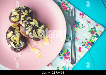 Gustosi eclair fatti in casa in un piatto con cioccolato e noci. Foto Stock