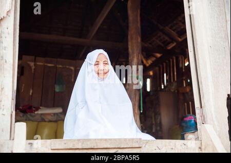 Un ritratto di un anziano di villaggio che indossa un abito bianco in un villaggio rurale di Cham. Cambogia centrale, Sud-est asiatico Foto Stock