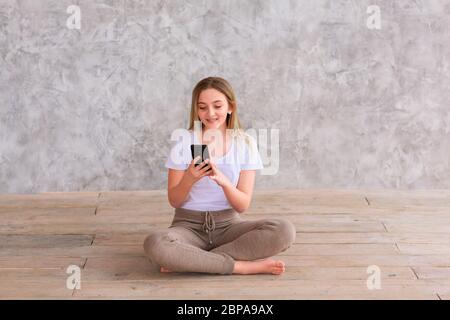 Adolescente ragazza che studia con il suo smartphone a casa durante isolamento quarantena durante la pandemia coronavirus. Concetto di soggiorno a casa Foto Stock