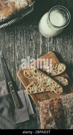 Piatto di calice di latte con ciabatta artigianale di pane su tavola di legno alimentare blog ricetta copia spazio prima colazione idea Foto Stock