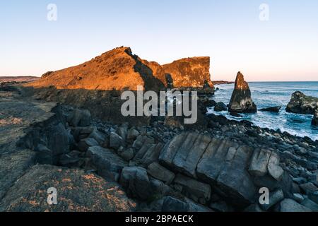 Meraviglioso tramonto sulla popolare attrazione turistica baia di Valahnukamol, nel sud dell'Islanda. Le scogliere si trovano nella penisola di Reykjanes e sono facilmente raggiungibili Foto Stock