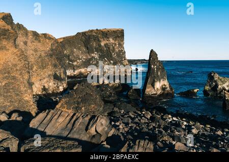 Meraviglioso tramonto sulla popolare attrazione turistica baia di Valahnukamol, nel sud dell'Islanda. Le scogliere si trovano nella penisola di Reykjanes e sono facilmente raggiungibili Foto Stock