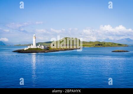 Lismore Faro con le verdi colline dell'isola di Eilean Musdile sullo sfondo - vista dal traghetto tra Oban e l'Isola di Mull, Scozia Foto Stock