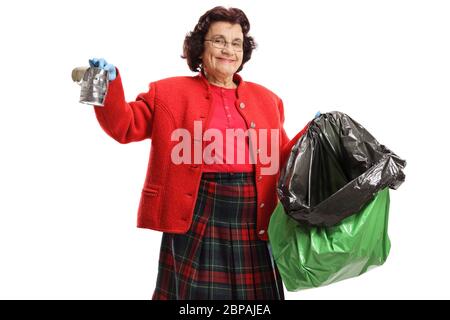 Donna anziana che raccoglie una lattina in una busta di plastica isolata su sfondo bianco Foto Stock