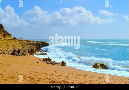 Persone che camminano nella primavera di sole sulla spiaggia di Albufeira in Portogallo Foto Stock