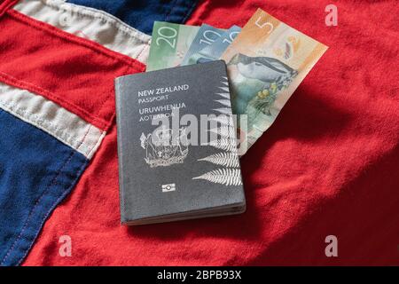 Passaporto della Nuova Zelanda sulla bandiera del paese con valuta. Foto Stock