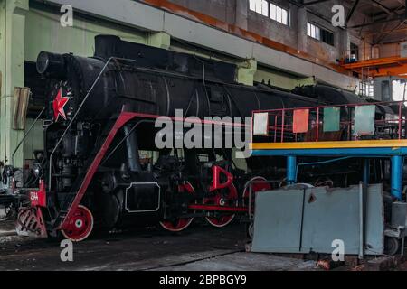 Vecchia locomotiva a vapore sovietica presso il deposito dei treni Foto Stock