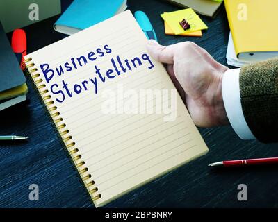Frase scritta a mano sulla pagina che racconta storie di business. Foto Stock