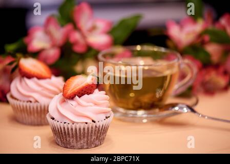 Cupcake al cioccolato con fragole. Cupcake con una tazza di tè. Messa a fuoco selettiva. Foto Stock