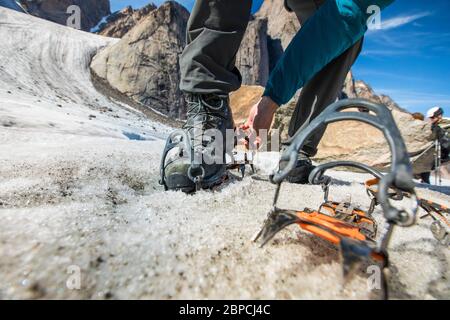 L'arrampicatore si arrampicava sui ramponi ai suoi stivali montanatineering sul ghiacciaio. Foto Stock