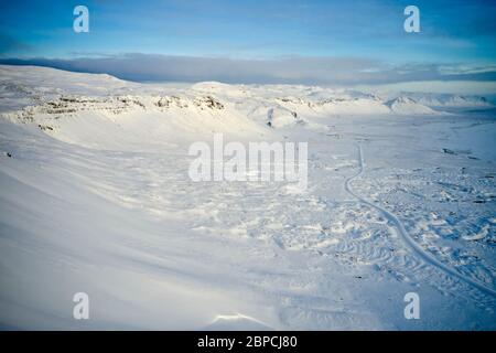 Vista aerea della catena montuosa innevata con dolci pendii situati nella valle dell'altopiano in Islanda Foto Stock