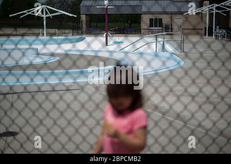 Manhattan, Kansas, Stati Uniti. 17 maggio 2020. MAIYA GONZALEZ, 2.5 anni, si trova all'ingresso della piscina Cico, ora chiusa. Con la chiusura delle piscine pubbliche i genitori devono trovare nuovi modi per intrattenere i loro bambini durante la pandemia COVID-19. Credit: Luke Townsend/ZUMA Wire/Alamy Live News Foto Stock