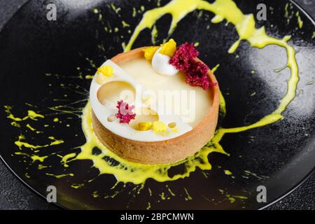 Una mano dello chef Pasticceria grattuce il limone in cucina commerciale.  Lo chef grates si lime sulla grattugia per ottenere la scorza per cucinare,  la preparazione di pasticceria, cibo sano Foto stock - Alamy