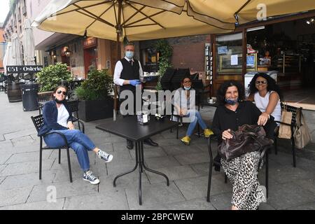 Bologna, Italia. 19 maggio 2020. La gente aspetta di bere un caffè in un bar a Bologna, 18 maggio 2020. Lunedì, è entrato in vigore il terzo e più grande allentamento della chiusura di dieci settimane. Negozi, ristoranti, bar, barbeauty salon, musei e operatori di fronte alla spiaggia sono tutti autorizzati a riaprire, purché rispettino le regole per la distanza sociale tra il personale e i membri del pubblico e le strutture di disinfezione. Gli italiani possono anche spostarsi all'interno della regione in cui vivono. (Foto di Gianni Schicchi/Xinhua) Credit: Xinhua/Alamy Live News Foto Stock