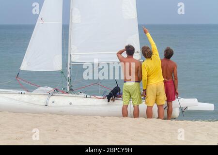 Un gruppo di uomini con un capitano in piedi vicino al yacht a vela bianco, Mar Nero, Zatoka, Odesa, Ucraina Foto Stock