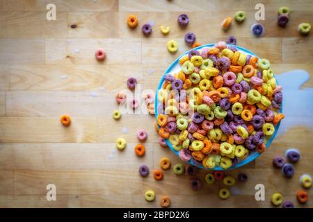 Ciotola colorata di cereali che si stillano sopra il piano del tavolo in legno, piatto. Foto Stock