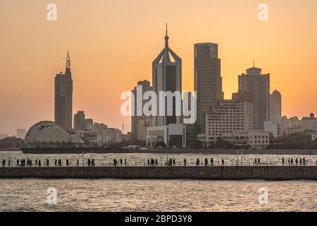 QINGDAO, CINA - NOVEMBRE 14: Vista degli alti edifici della città e del Molo di Zhanqiao lungo il lungomare durante il tramonto il 14 Novembre 2019 a Qingdao Foto Stock