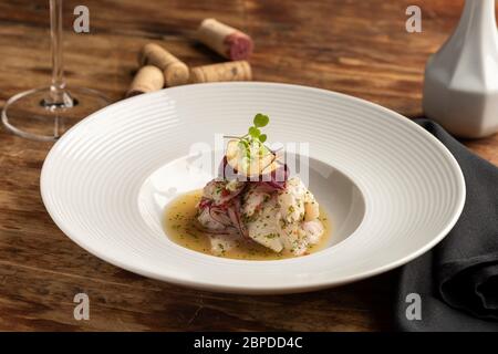 Pesce ceviche cebiche cebiche su un tavolo di legno e bicchiere di vino e tappi, piatto tipico del Perù. Foto Stock