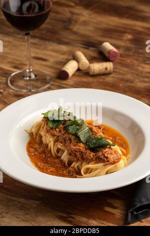 Pasta tagliatelle alla bolognese con manzo macinato rosso su piatto bianco e fondo sfocato. Foto Stock