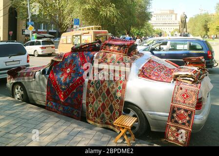 Tappeti in vendita esposti sulla vettura al mercato Vernissage a Yerevan, la città capitale dell'Armenia Foto Stock