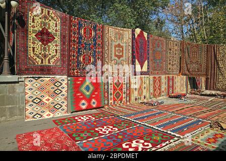 Vari modelli di tappeti in vendita al mercato Vernissage nel centro di Yerevan, Armenia Foto Stock