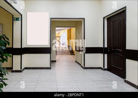 Un corridoio vuoto in un moderno edificio di uffici. Una sala con pareti chiare e porte marroni. Foto Stock