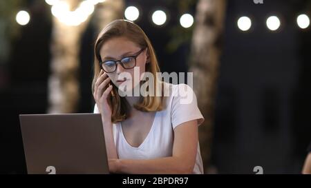 ?ipster ragazza in conversazione casuale via telefono mobile e facendo freela Foto Stock