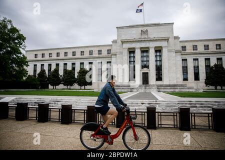 WASHINGTON, DC, DC, USA. 18 maggio 2020. Un ciclista che indossa una maschera cavalcate dall'edificio della Federal Reserve degli Stati Uniti a Washington, DC, Stati Uniti il 18 maggio 2020. Jerome Powell, presidente della Federal Reserve americana, ha dichiarato in un'intervista a CBS News '60 minuti' domenica che l'economia statunitense potrebbe ridurre di oltre il 30% nel secondo trimestre. Credit: Ting Shen/Xinhua/Alamy Live News Foto Stock
