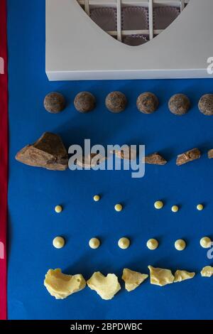 Pezzi di cioccolato fondente naturale e cioccolato bianco, una scatola di cioccolatini a forma di cuore bianco e un nastro rosso giacciono su uno sfondo blu Foto Stock