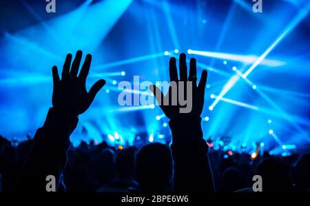 Concerto di musica, silhouette di Le Mans in alto le mani, la folla di gente, attiva vita notturna, vacanze celebrazione in dance club, il piacere e il divertimento concept Foto Stock