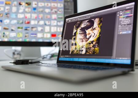 Fotografi computer con applicazioni/programmi di editing fotografico in esecuzione - immagini su cui si lavora, finemente sintonizzate per guardare al meglio. Moderne apparecchiature informatiche in un Foto Stock