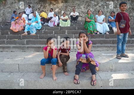 Bambini giocosi e anziani di una famiglia indiana estesa, uomini e donne, visitando il sito sacro (indù) Banganga Tank a Walkeshwar, Mumbai, India Foto Stock