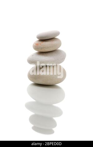 Pila di ciottoli di bilanciamento di pietre, come ZEN Stone, isolato su sfondo bianco, spa tranquillo concetto della scena con la riflessione Foto Stock