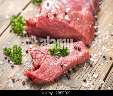 Crudo fresco di carne di manzo fetta su sfondo di legno Foto Stock