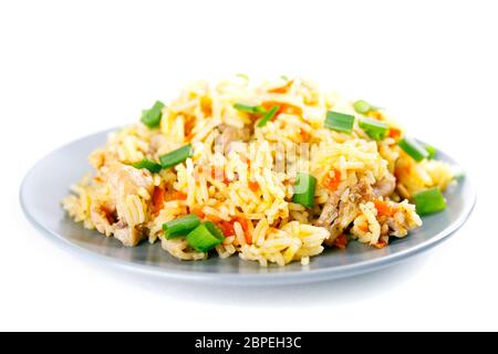 Fragrante Pulav pilaf pilaf pilaf, riso fritto con carne e verdure su una lastra grigia. Isolato su bianco. Macro. Foto Stock