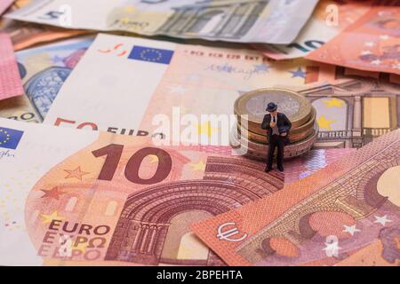 Banchiere mit Geld, Münzen und Scheinen der Währung Euro Foto Stock