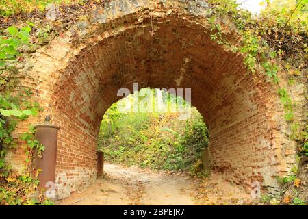 Strada di sabbia sotto arco storico da mattoni rossi in Kachanivka park Foto Stock