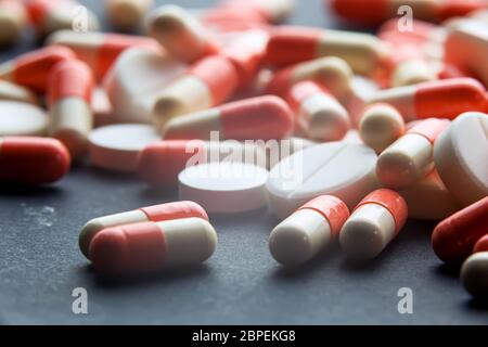 Tema farmacia heap di rosso arancio bianco capsula pillole rotonde con antibiotico farmaco in confezioni. Prescrizione del farmaco per il trattamento. Farmacia Foto Stock