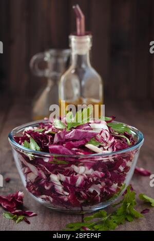 Shredded cavolo rosso in recipiente di vetro con prezzemolo e olio. Foto Stock