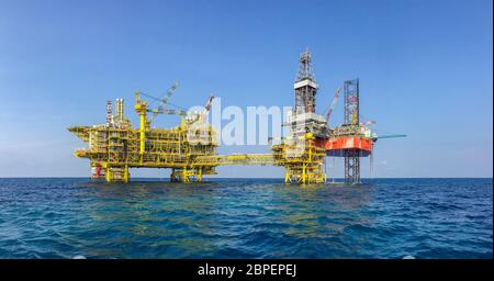 Industria petrolifera e del gas. Panorama di carri di perforazione con camicia rossa sulla piattaforma della testa del pozzo nel mezzo del mare. Nuova piattaforma per petrolio e gas installata Foto Stock