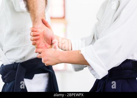 L uomo e la donna di combattere ad Aikido la formazione nella scuola di arti marziali Foto Stock