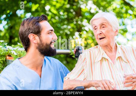 L'infermiera avente chat con il senior donna nella casa di cura Foto Stock