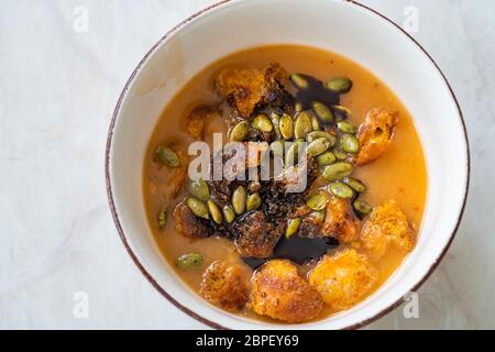 Zuppa di zucca fatta in casa con salsa di zucca, semi di zucca, carote e croccante pane crostini. Cibo sano e biologico. Foto Stock