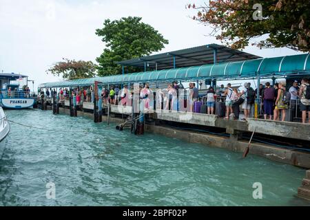 Ko Pha-ngan / Thailandia - Febbraio 2020: Molo isola tropicale con turisti e barca. Turisti in attesa di salire a bordo del traghetto Haad Rin Queen a Haad Rin Foto Stock